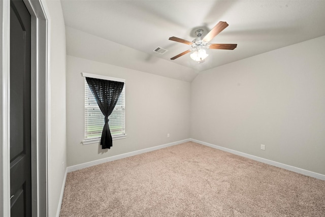 carpeted empty room with vaulted ceiling, baseboards, a ceiling fan, and visible vents