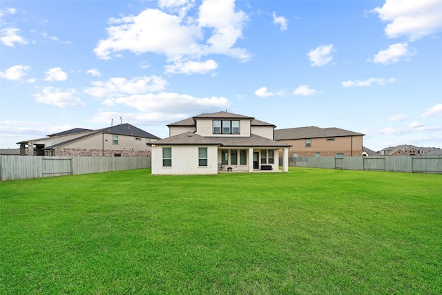 back of house with a yard, roof with shingles, and a fenced backyard