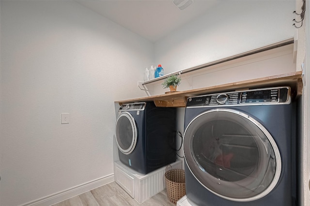 1672 Happy Valley St, Montgomery, TX 77316 - clothes washing area with washing machine and clothes dryer, light wood-style floors, baseboards, and laundry area
