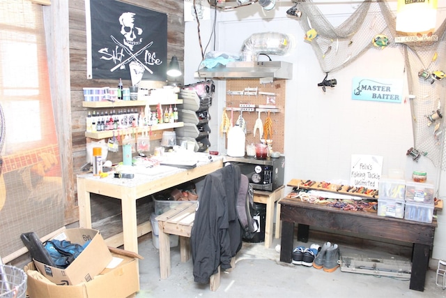 miscellaneous room with concrete flooring and a workshop area