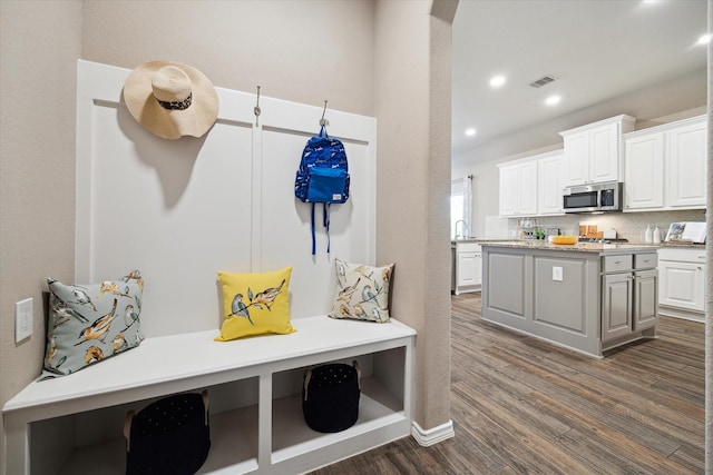 mudroom featuring a sink, dark wood-type flooring, visible vents, and recessed lighting