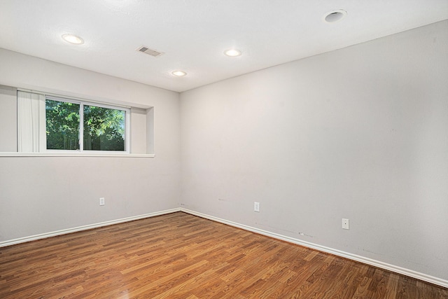 empty room featuring recessed lighting, baseboards, visible vents, and wood finished floors