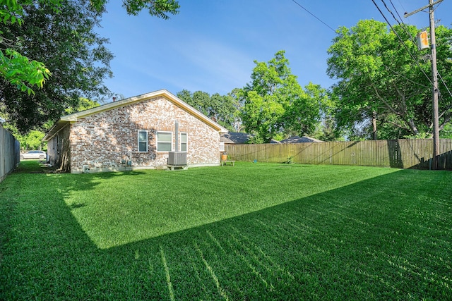 view of yard featuring a fenced backyard and central air condition unit