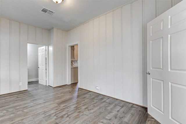 unfurnished bedroom featuring visible vents and wood finished floors