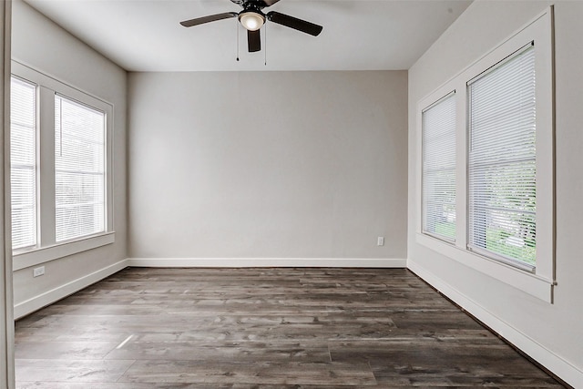 spare room with dark wood-style floors, ceiling fan, and baseboards