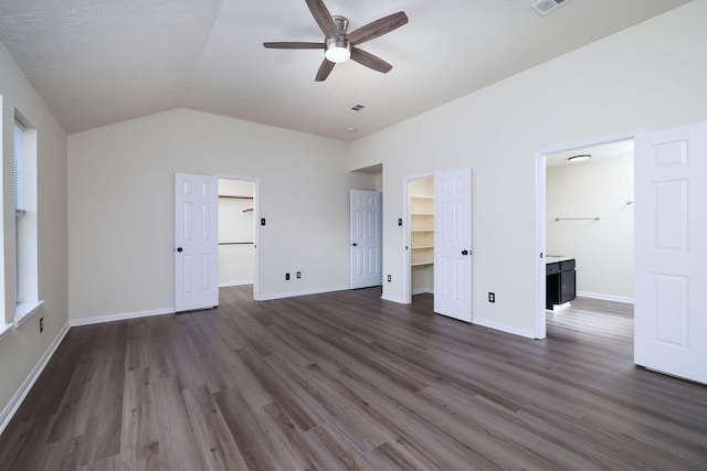 6902 Woodland Oaks, Magnolia, TX 77354 - unfurnished bedroom featuring lofted ceiling, dark wood-style flooring, visible vents, and a walk in closet