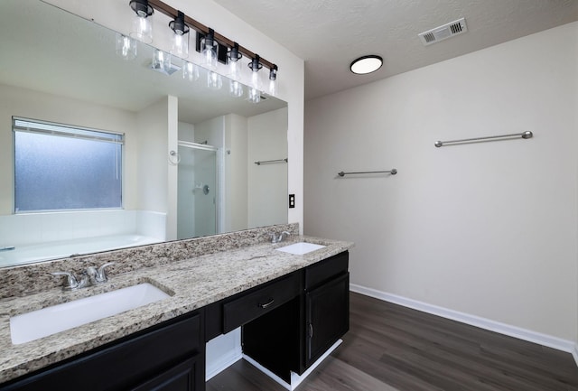 6902 Woodland Oaks, Magnolia, TX 77354 - bathroom with a stall shower, visible vents, a sink, and wood finished floors