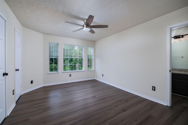 6902 Woodland Oaks, Magnolia, TX 77354 - unfurnished bedroom featuring a textured ceiling, baseboards, and dark wood finished floors