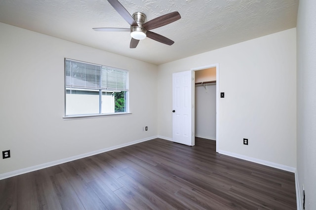 6902 Woodland Oaks, Magnolia, TX 77354 - unfurnished bedroom featuring ceiling fan, a walk in closet, baseboards, and dark wood-type flooring