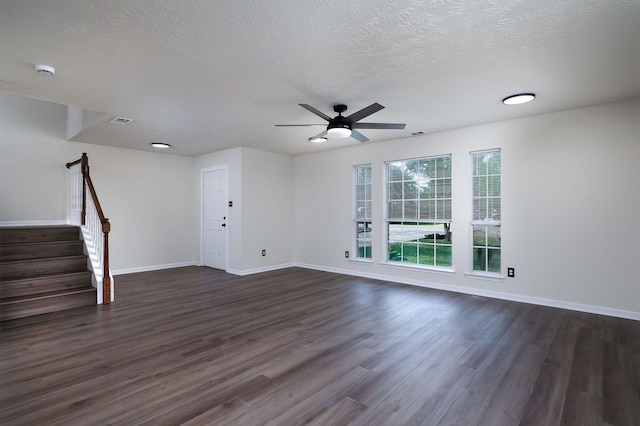 6902 Woodland Oaks, Magnolia, TX 77354 - unfurnished living room with a ceiling fan, a textured ceiling, dark wood-type flooring, baseboards, and stairs