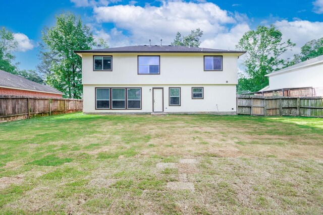 6902 Woodland Oaks, Magnolia, TX 77354 - rear view of house with stucco siding, a lawn, and a fenced backyard
