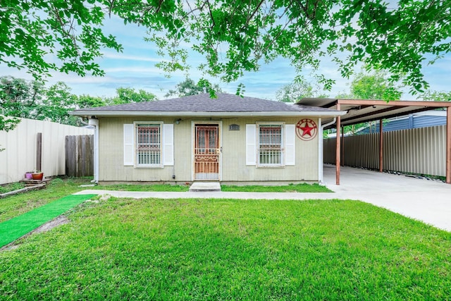 view of front of property featuring driveway, an attached carport, a front yard, and fence