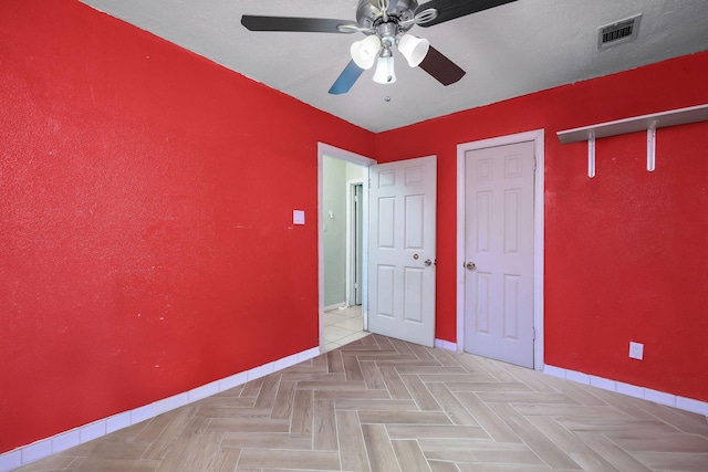 unfurnished bedroom featuring ceiling fan, baseboards, and visible vents