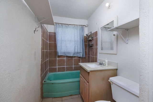 bathroom with toilet, tile patterned floors, a textured wall, vanity, and shower / bathtub combination