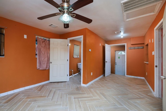 empty room featuring ceiling fan, baseboards, and visible vents