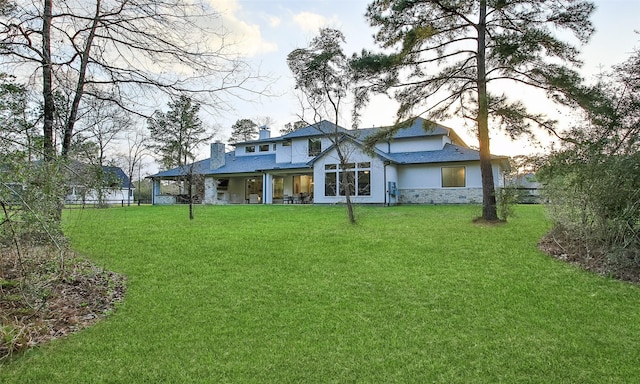 29314 Village Rdg, Magnolia, TX 77355 - rear view of house with a chimney, a yard, stucco siding, and stone siding