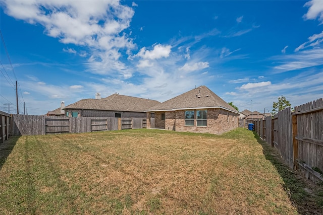19911 Whistle Creek Ln, Cypress, TX 77433 - rear view of house with a yard, brick siding, and a fenced backyard