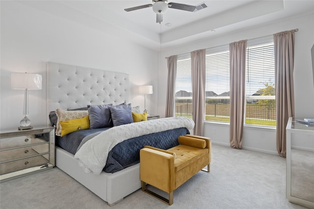 31811 Snapdragon Glen Trl, Hockley, TX 77447 - bedroom with light colored carpet, multiple windows, a ceiling fan, and a raised ceiling
