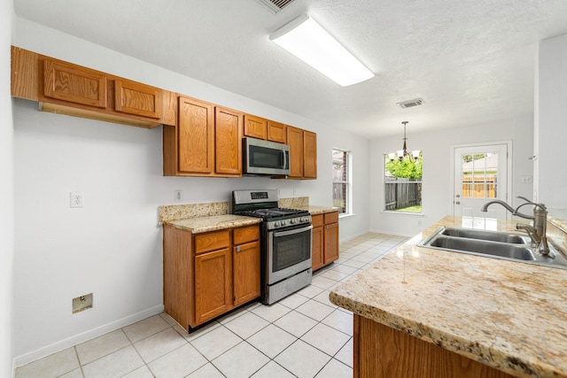 5315 Cilantro Ln, Baytown, TX 77521 - kitchen featuring stainless steel appliances, a sink, brown cabinets, light countertops, and light tile patterned floors