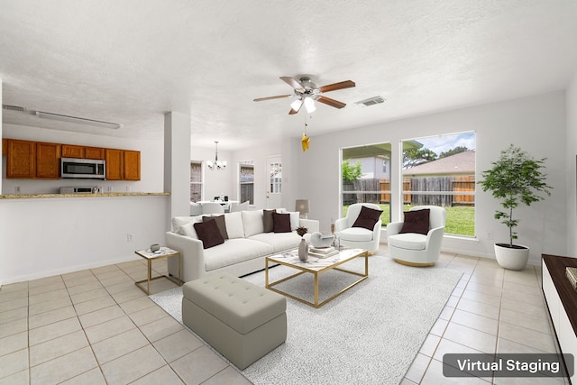 5315 Cilantro Ln, Baytown, TX 77521 - living area featuring light tile patterned floors, a ceiling fan, a chandelier, a textured ceiling, and baseboards