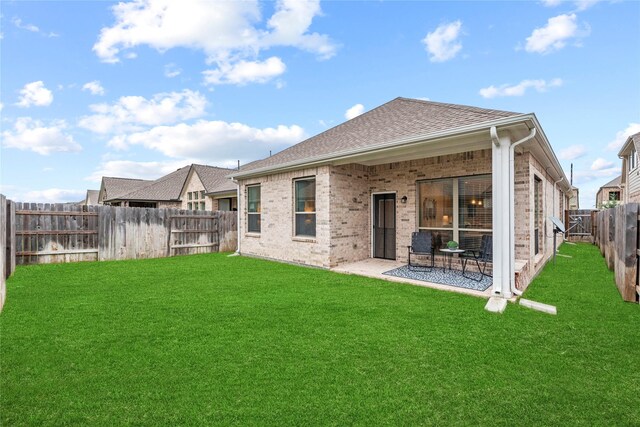 7015 Winterberry Glen Ln, Katy, TX 77493 - back of property with roof with shingles, brick siding, a yard, a patio, and a fenced backyard
