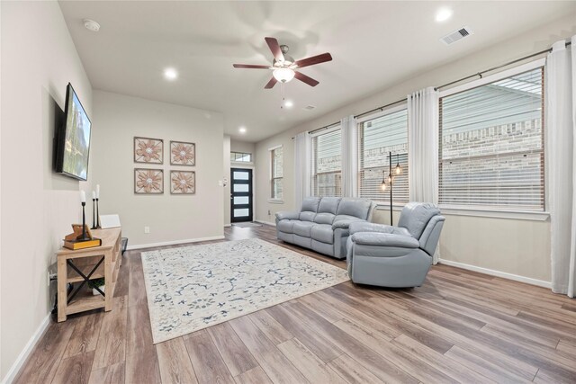 7015 Winterberry Glen Ln, Katy, TX 77493 - living area featuring wood finished floors, visible vents, baseboards, and ceiling fan