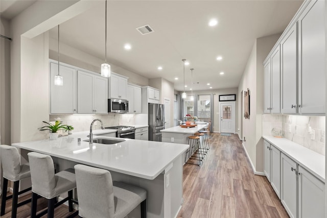 7015 Winterberry Glen Ln, Katy, TX 77493 - kitchen featuring stainless steel appliances, a kitchen breakfast bar, visible vents, decorative backsplash, and recessed lighting