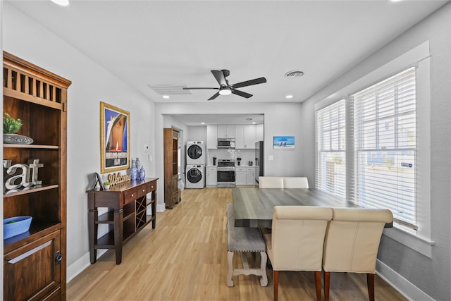 1802 Ursuline St, Galveston, TX 77550 - dining room with light wood-type flooring, visible vents, stacked washer / dryer, and a ceiling fan