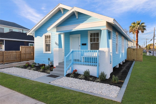 1802 Ursuline St, Galveston, TX 77550 - view of front facade with covered porch, fence, and a front lawn