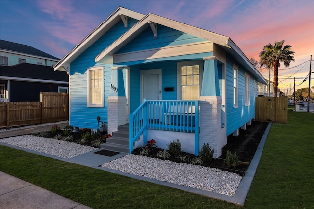1802 Ursuline St, Galveston, TX 77550 - shotgun-style home with a porch, fence, and a front yard