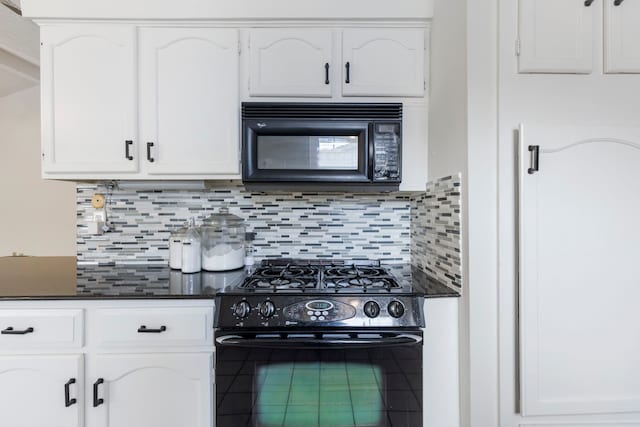 kitchen with black appliances, white cabinetry, and backsplash