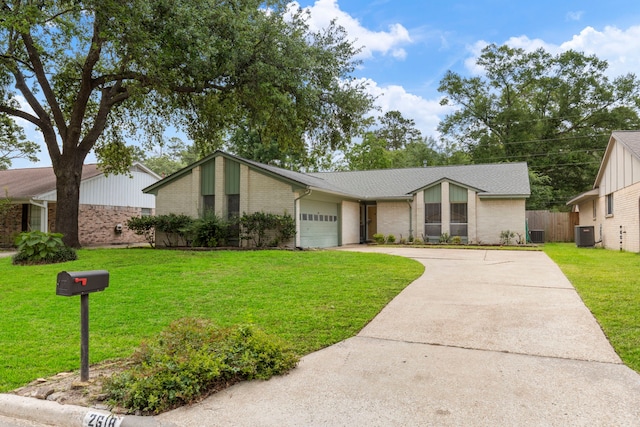 mid-century home with driveway, brick siding, an attached garage, and central AC