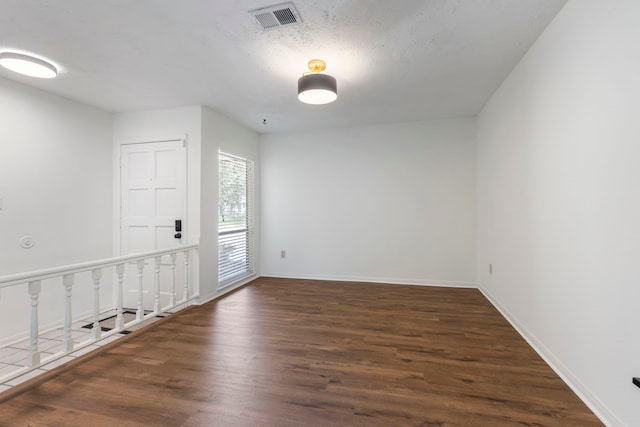 spare room with wood finished floors and baseboards
