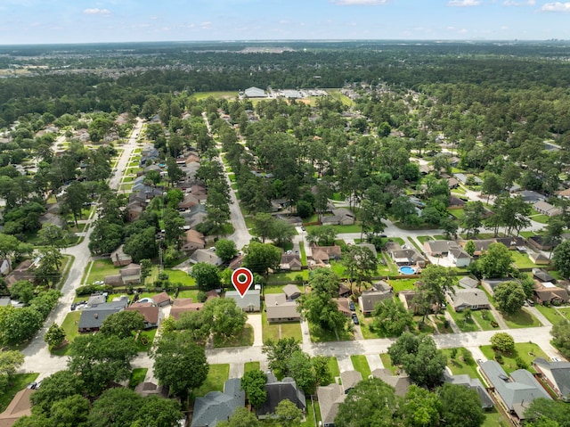 aerial view of property's location featuring nearby suburban area and a heavily wooded area