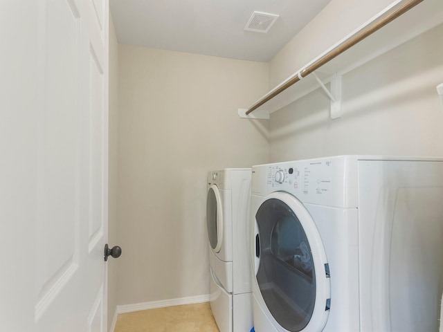 laundry area with laundry area, washer and clothes dryer, visible vents, and baseboards