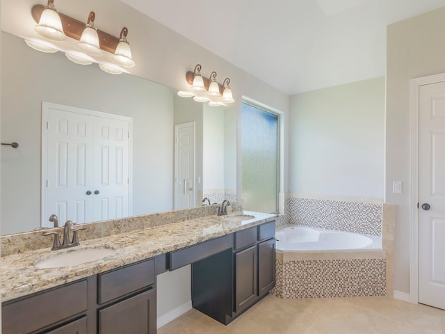 bathroom featuring a sink, double vanity, a garden tub, and tile patterned flooring