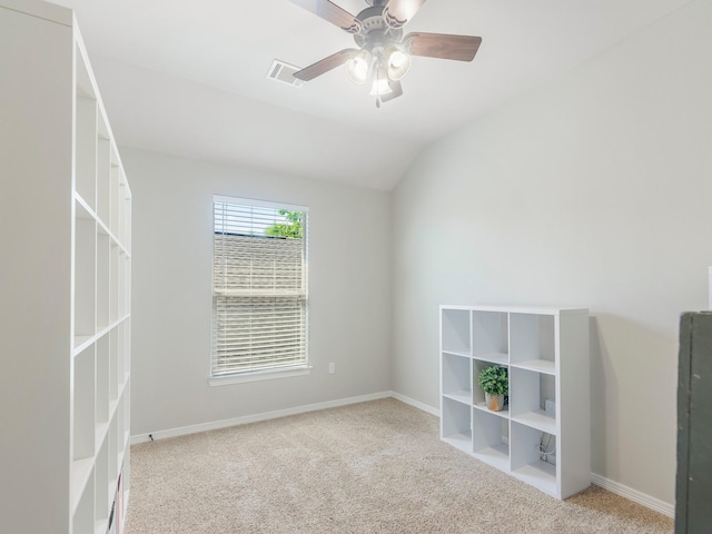 empty room featuring a ceiling fan, carpet, baseboards, visible vents, and vaulted ceiling