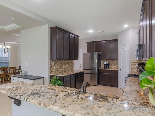 kitchen featuring light tile patterned flooring, backsplash, a notable chandelier, and appliances with stainless steel finishes