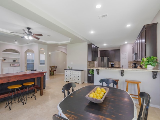 dining area featuring visible vents, light tile patterned flooring, arched walkways, and recessed lighting