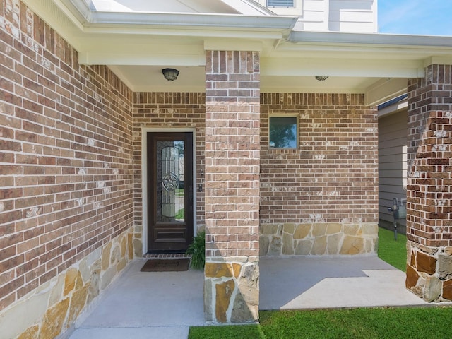 doorway to property featuring brick siding