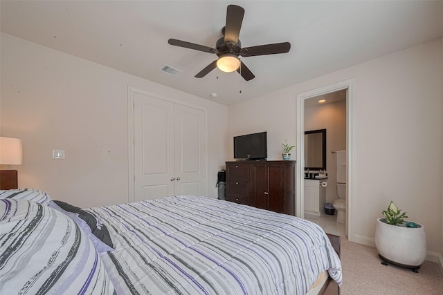 2303 Hadley St, Houston, TX 77003 - bedroom featuring a closet, light colored carpet, ensuite bath, ceiling fan, and baseboards