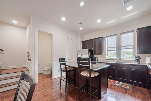 2303 Hadley St, Houston, TX 77003 - kitchen featuring a sink, wood finished floors, a kitchen breakfast bar, freestanding refrigerator, and a kitchen island