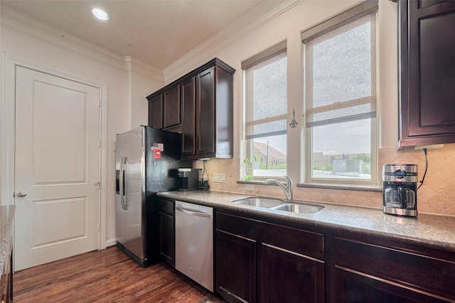 2303 Hadley St, Houston, TX 77003 - kitchen with appliances with stainless steel finishes, a sink, ornamental molding, tasteful backsplash, and dark wood finished floors