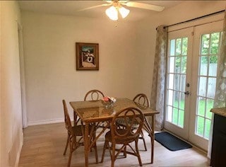 dining area with light wood finished floors, baseboards, french doors, and a ceiling fan