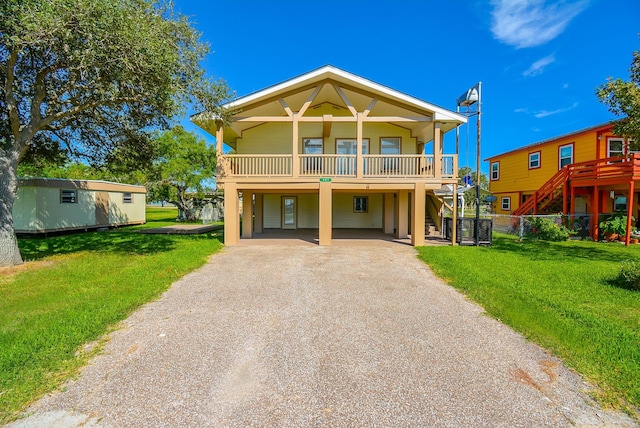 beach home featuring a front yard, a carport, and aphalt driveway