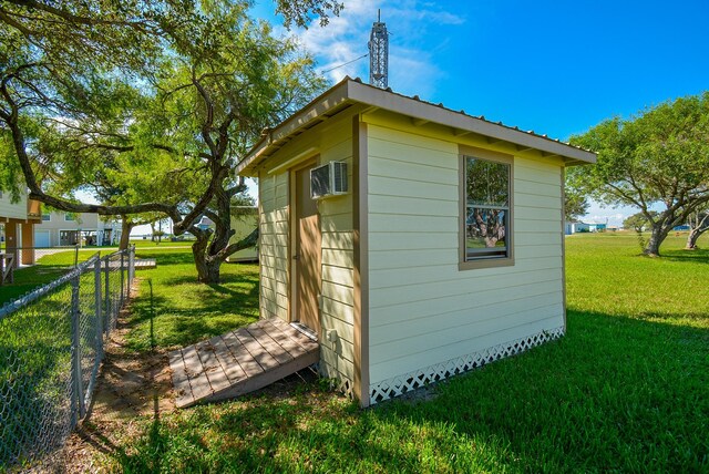 view of shed with a wall mounted air conditioner and fence