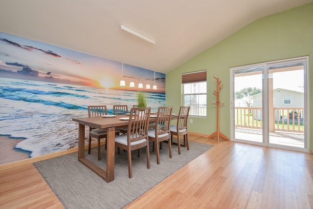 dining area featuring lofted ceiling, baseboards, and wood finished floors