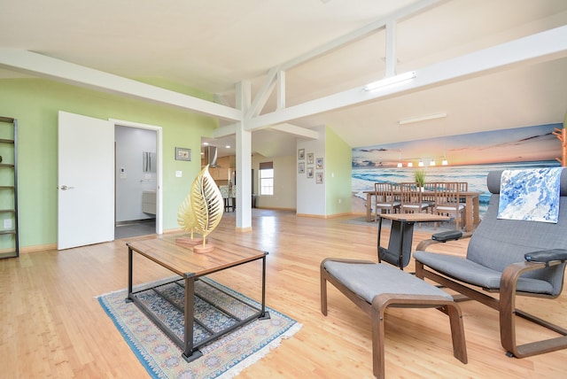 living area with baseboards, wood finished floors, and lofted ceiling