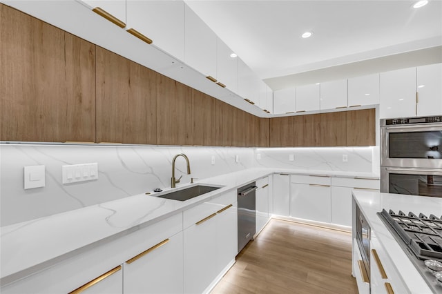 602 W 28th St Unit B, Houston, TX 77008 - kitchen with light wood-style floors, appliances with stainless steel finishes, modern cabinets, and a sink