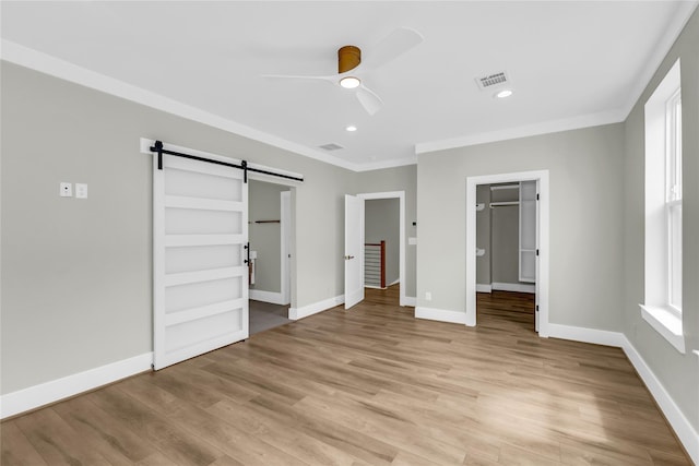 602 W 28th St Unit B, Houston, TX 77008 - unfurnished bedroom featuring crown molding, light wood-style floors, visible vents, and a barn door